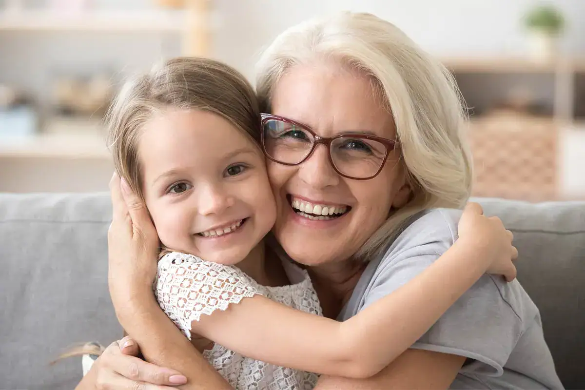 Grandmother Grandchild Hugging On Sofa