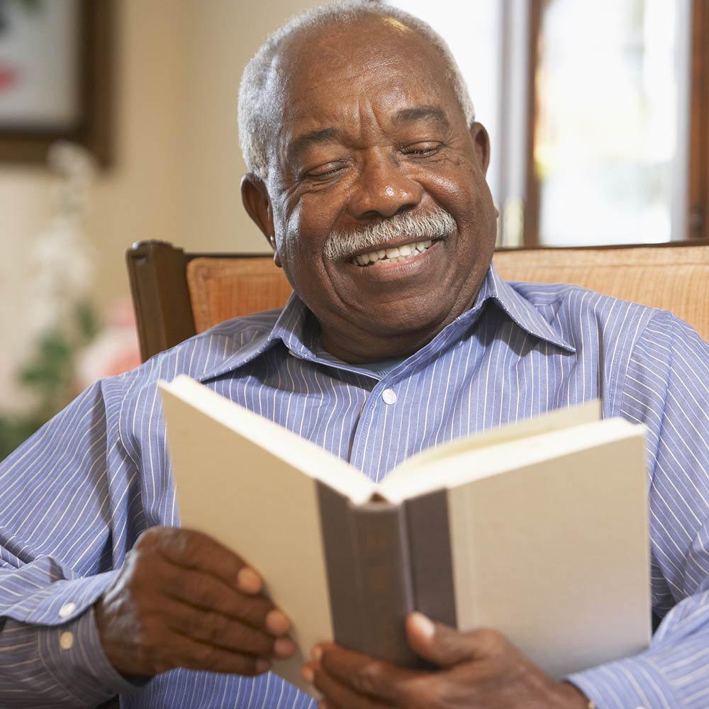 Senior African American Man Reading in Chair